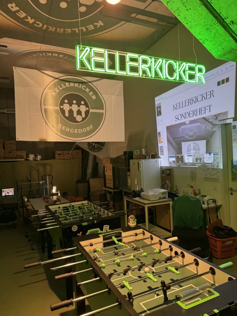 Der Keller mit Neonschild, Fahne und dem Sonderheft an der Wand